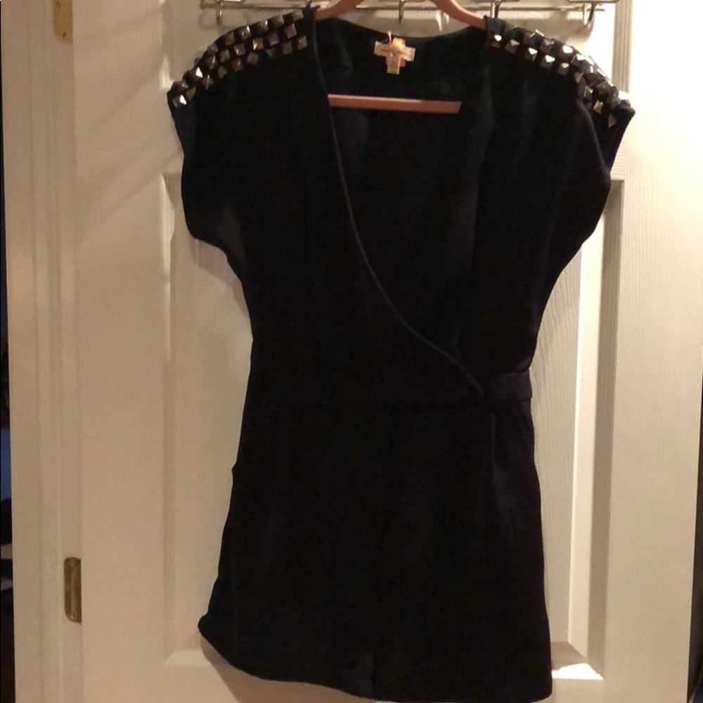 Black romper with accessorized shoulders.